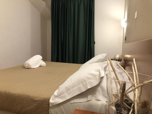 a bedroom with a bed with white sheets and pillows at Hotel Kristall in Orvieto