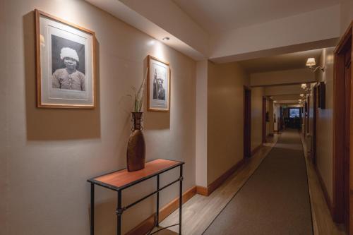 a hallway with a vase on a table and a picture on the wall at Altos Ushuaia Hotel & Resto in Ushuaia