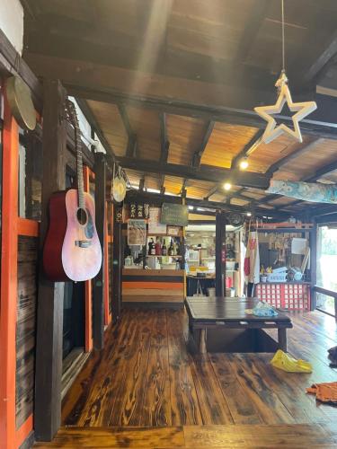 una guitarra colgada en la pared de un restaurante en 月光荘沖縄, en Naha