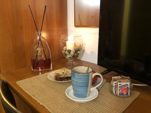 a table with a cup of coffee and a plate of cake at Hotel Kristall in Orvieto