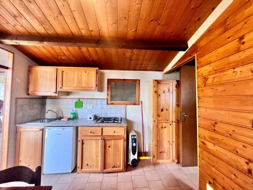 a kitchen with wooden cabinets and a white refrigerator at Villaggio Smeraldo in Moneglia