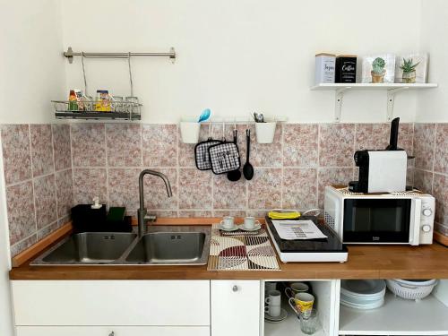 a kitchen with a sink and a microwave at Be Home in Pontecagnano