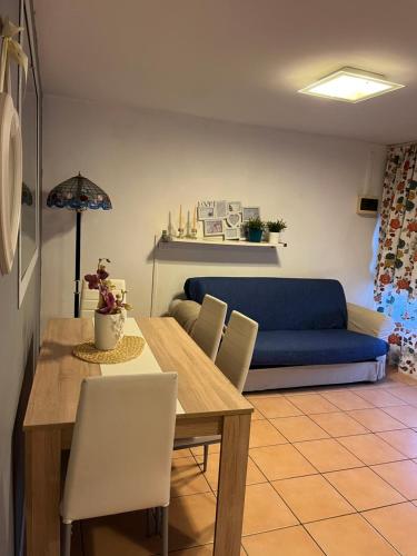 jadalnia ze stołem i niebieską kanapą w obiekcie Da Esterina appartamento sulla riviera del Brenta w mieście Mira