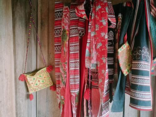 um monte de cortinas coloridas penduradas numa parede em TẠ QUYÊN HOMESTAY em Ha Giang
