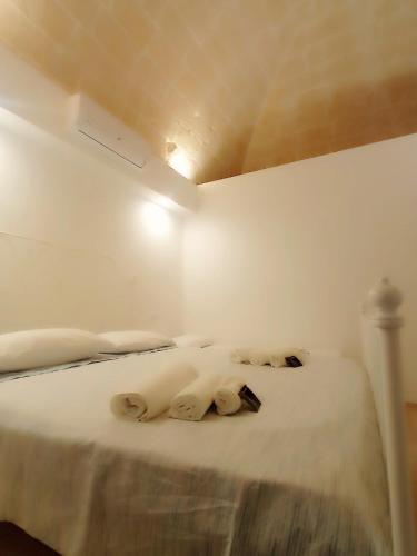 a white bed in a room with a ceiling at STRADONE 132 in Gravina in Puglia
