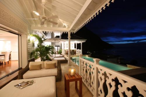 a balcony of a house with a couch and a table at Sugar Beach, A Viceroy Resort in Soufrière