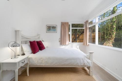 a white bedroom with a bed and a window at Sunny Beach Holiday Home 80 in Kingston Beach