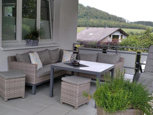 een patio met een bank en een tafel op een balkon bij Ferienwohnung Zweite Heimat in Schmallenberg