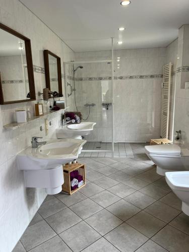 a bathroom with three sinks and a shower at Ferienwohnung Göttert – Haus Erika in Beckingen