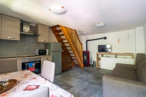 a kitchen with a table and a staircase in a room at Residence Covalou in Antey-Saint-André