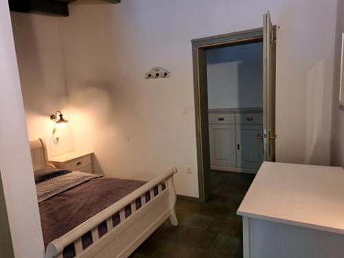 a bedroom with a bed and a door to a kitchen at Penzion U vinaře in Velké Bílovice