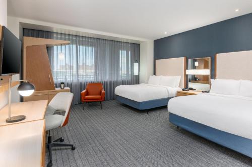 a hotel room with two beds and a desk at Courtyard by Marriott Buffalo Downtown/Canalside in Buffalo