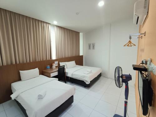 a hotel room with two beds and a camera at Hotel Wawasan in Simpang Renggam