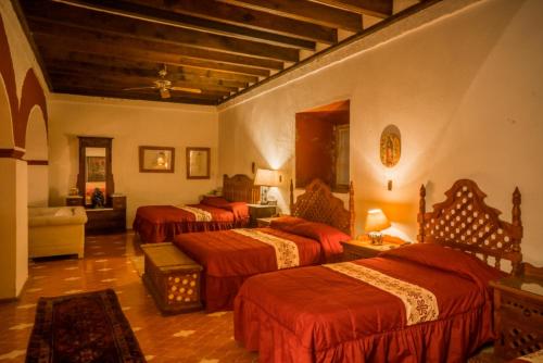 een slaapkamer met 3 bedden en rode lakens bij Hacienda de San Ignacio in San Ignacio