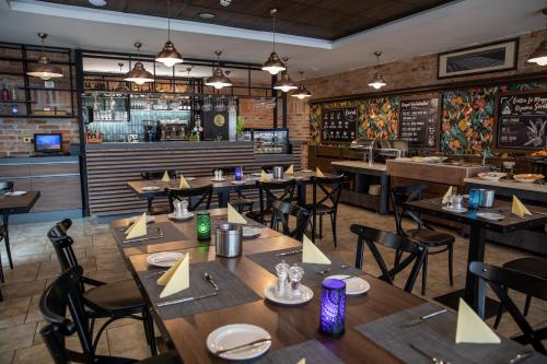 a restaurant with tables and chairs and a bar at City Hotel Miskolc in Miskolc