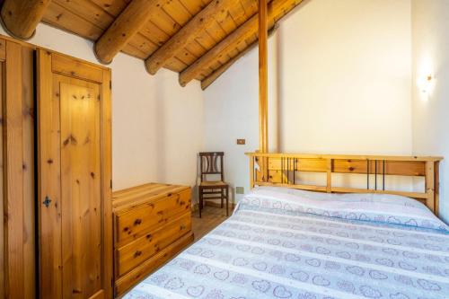 a bedroom with a wooden bed and a wooden cabinet at Residence Covalou in Antey-Saint-André