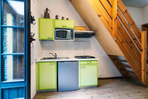 a small kitchen with green cabinets and a microwave at Residence Covalou in Antey-Saint-André