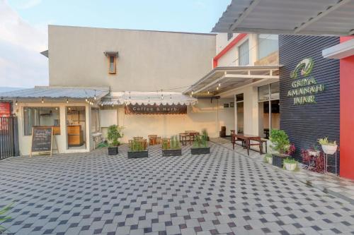 a patio with tables and chairs in front of a building at OYO Capital O 90410 Griya Amanah Jajar Syariah in Solo