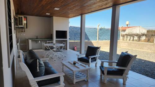 sala de estar con sofá, sillas y mesa en DEPARTAMENTOS CIELO DE CAFAYATE en Cafayate