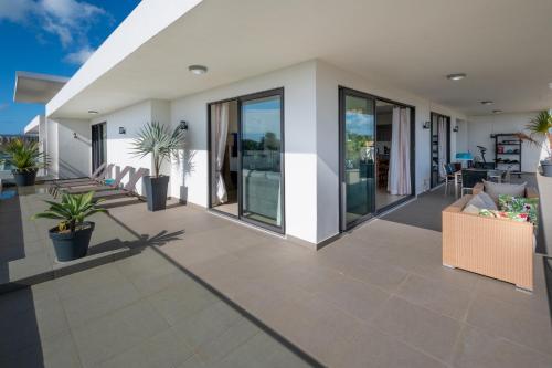 格兰贝伊PENTHOUSE VUE MER - MONT CHOISY的一间设有玻璃门和盆栽植物的客厅