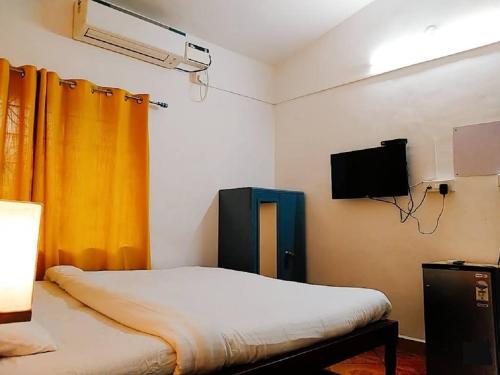 - une chambre avec un lit et une télévision dans l'établissement Baga Sea Link, à Baga