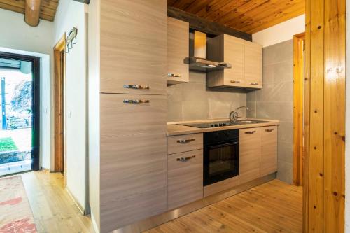 a kitchen with wooden cabinets and a sink and a stove at Residence Covalou in Antey-Saint-André