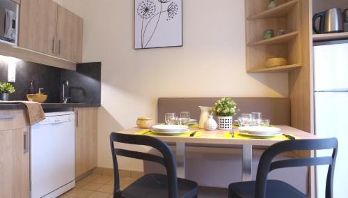 a kitchen with a table with chairs and glasses on it at VVF Bourgogne Auxois Morvan in Semur-en-Auxois