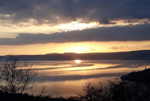a sunset over a large body of water at Il Giardino Fiorito in Trevignano Romano
