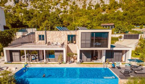an aerial view of a house with a swimming pool at New luxury villa with 17m pool and bay view in Kotor