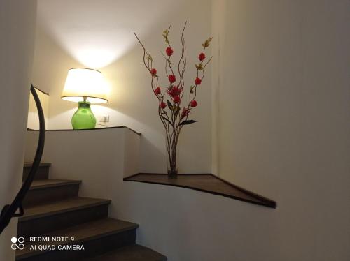 a vase with flowers on a wall next to stairs at Il Giardino Fiorito in Trevignano Romano