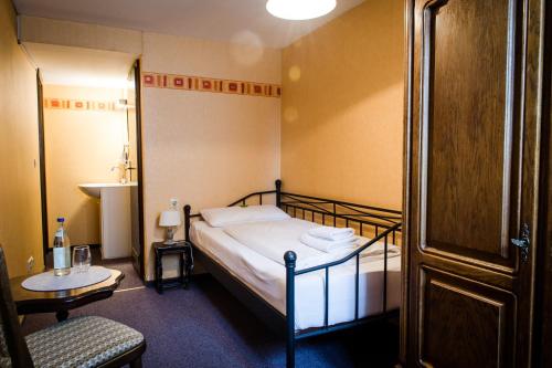 1 dormitorio con 1 cama, 1 mesa y 1 silla en Hotel Schwarzer Adler en Rothenburg ob der Tauber