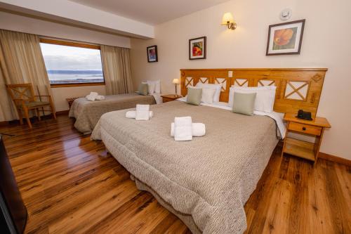 a hotel room with two beds and a television at Altos Ushuaia Hotel & Resto in Ushuaia