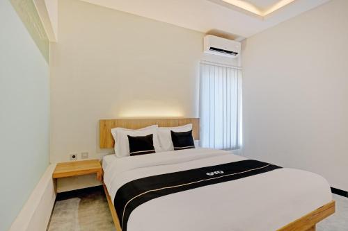 a bedroom with a white bed and a window at OYO Capital O 90410 Griya Amanah Jajar Syariah in Solo