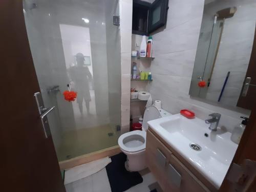 a bathroom with a sink and a toilet and a mirror at Appartement plage Mehdia in Plage de Mehdia