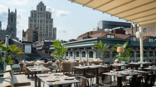 a restaurant with tables and chairs on the roof of a building at Hotel Nelligan in Montréal