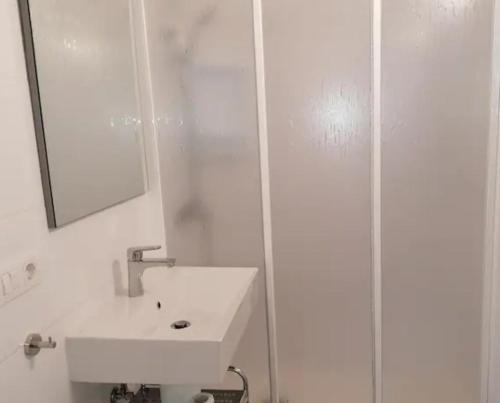 Un baño blanco con lavabo y espejo. en Vivienda El Remo-Vv-1, en Los Llanos de Aridane