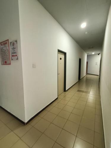 an empty hallway with white walls and tile floors at Hotel Wawasan in Simpang Renggam
