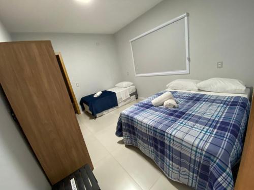 a bedroom with two beds and a large window at Pousada Ametista - Penha, SC - 1,5 km do Parque Beto Carrero World in Penha