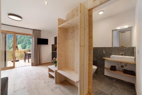a bathroom with a wooden partition with a sink at Herrischner Apartement 2 in Corvara in Passiria