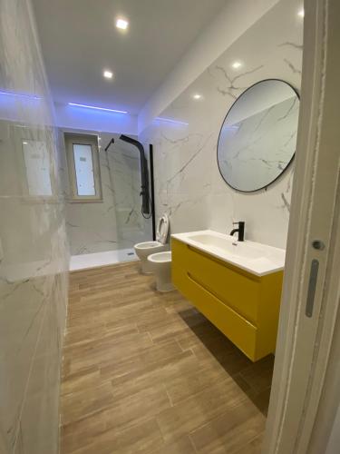 bagno con lavandino, specchio e 2 servizi igienici di G’S HOME a Margherita di Savoia