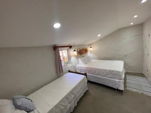 a bedroom with two beds and a window at Beira-mar Chácara Curimãs - Barroquinha, Ceará in Barroquinha