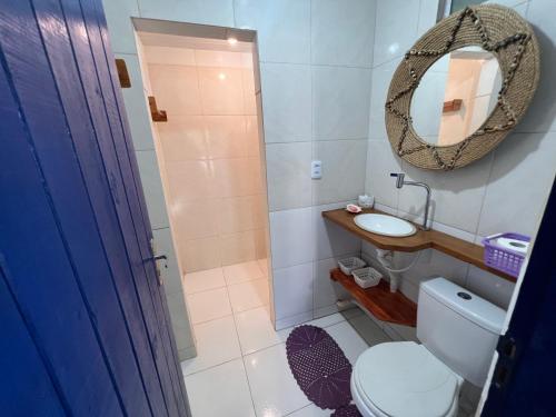 a bathroom with a toilet and a sink and a mirror at Beira-mar Chácara Curimãs - Barroquinha, Ceará in Barroquinha