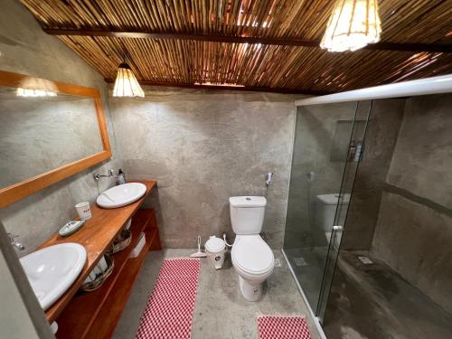 a bathroom with a toilet and a sink and a shower at Beira-mar Chácara Curimãs - Barroquinha, Ceará in Barroquinha