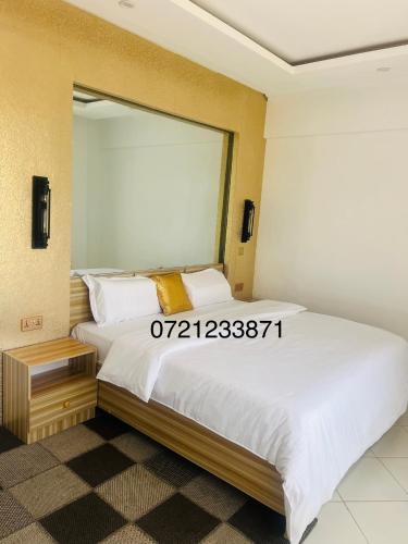 una camera da letto con un grande letto e un grande specchio di Regency Homes a Eldoret
