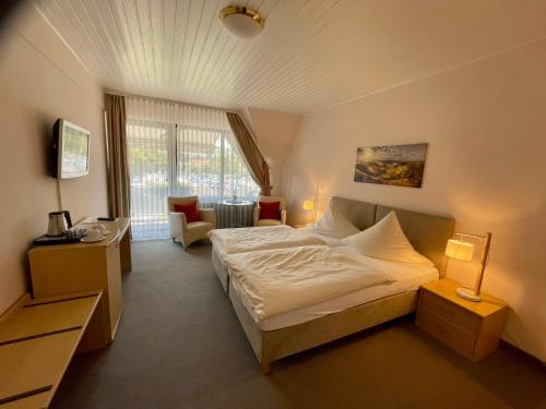 Pokój hotelowy z łóżkiem i krzesłem w obiekcie Der Schützenhof w mieście Bad Neuenahr-Ahrweiler