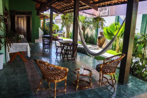 a patio with chairs and a hammock in a restaurant at Pousada Coconut Cumbuco in Cumbuco