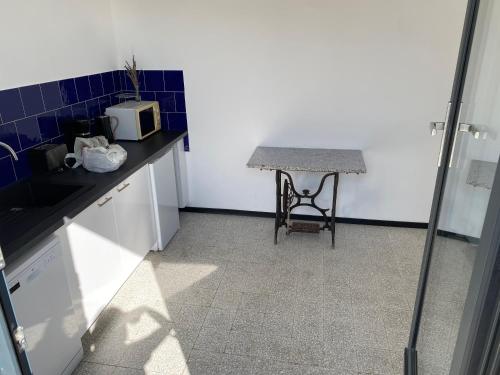 a small kitchen with a table and a microwave at VillaSarda Drome in Sauzet