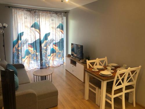 a living room with a table and a couch and a dining room at N&S Apartament na Lisiej in Zielona Góra