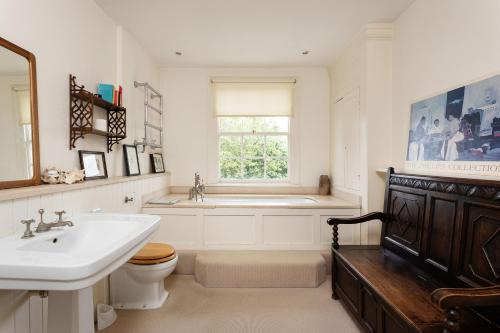 a bathroom with a sink and a toilet and a tub at Veeve - Eclectic Embrace in London