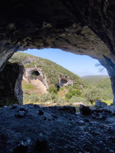 a view from inside a cave looking out at a mountain at O Refúgio das Buracas in Condeixa a Nova